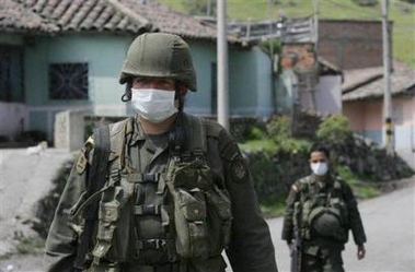 A police officer covers his face from the ashes from the Galeras volcano as he patrols the Mapachico streets near Pasto, about 330 miles southwest of Bogota, Colombia, Thursday, Nov.24, 2005. [AP]