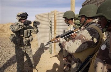 In this picture released by the U.S. Air Force on Nov. 24, 2005, Army Staff Sgt. Jason Lyday, left, instructs Iraqi Army soldiers on muzzle discipline prior to entering a room during a dry run of close quarters battle at weapons class on Forward Operations Base McHenry northern Iraq, near Kirkuk, Wednesday, Nov. 23, 2005.