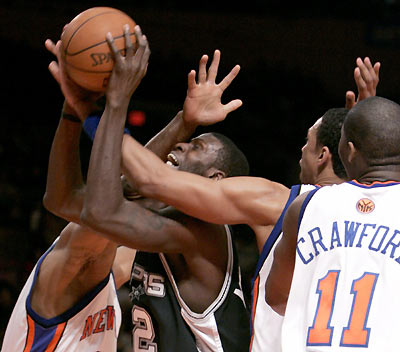 Antonio Spurs center Nazr Mohammed (C) is fouled as he tries to shoot between New York Knicks center Jerome James (L), center Channing Frye (2nd R) and guard Jamal Crawford in the second period of their NBA game in New York's Madison Square Garden December 21, 2005. [Reuters]