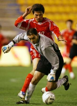 China's Li Yi (back) fights for the ball with Andalucia's Jose Antonio Luque before scoring on it during their friendly soccer match at the Ramon de Carranza Stadium in Cadiz, southern Spain December 28, 2005. 