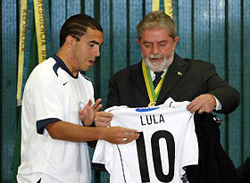 Brazil's President Luiz Inacio Lula da Silva (R) receives a jersey with his name from Argentine soccer player Carlos Tevez of Brazilian club Corinthians at Planalto Palace in Brasilia December 6, 2005. Corinthians claimed the Brazilian championship on December 5.