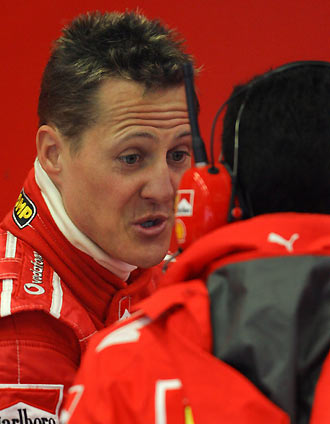 Ferrari's Formula One driver Michael Schumacher of Germany talks to a member of his team during a free practice session at the Jerez race track in southern Spain January 11, 2006. [Reuters]