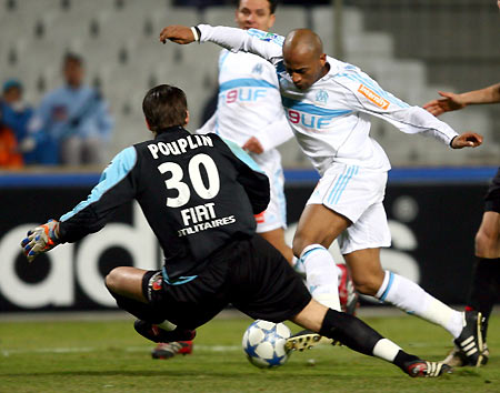 Olympique Marseille's Toifilou Maoulida (R) fights for the ball against Rennes goalkeeper Simon Pouplin during their French Ligue 1 soccer match at the Velodrome stadium in Marseille, January 15, 2006. [Reuters]