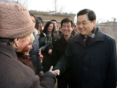 Chinese President Hu Jintao (R), also general secretary of the Communist Party of China (CPC) Central Committee and chairman of the CPC Central Military Commission, expresses his New Year greetings to local people in Hougoumen Village of Yanhewan Town in Ansai County.