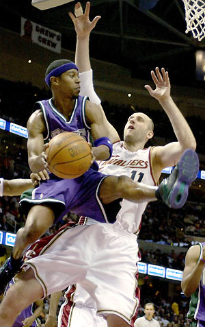 T. J. Ford of the Milwaukee Bucks looks for someone to pass the ball to as Zydrunas Ilgauskas of the Cleveland Cavaliers blocks during the fourth quarter of their NBA game at The Q in Cleveland, Ohio February 6, 2006. Cavaliers won 89-86. [Reuters]