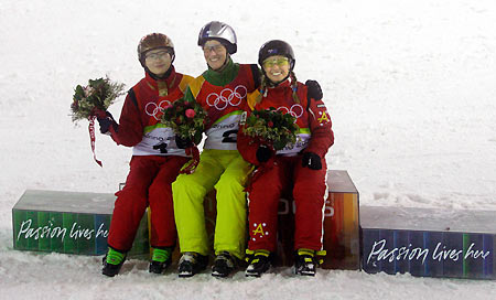 Evelyne Leu (C) of Switzerland celebrates during the final of the women's aerials freestyle competition at the Torino 2006 Winter Olympic Games in Sauze d扥ulx, Italy February 22, 2006. Leu is flanked by China's Li Nina (L) and Australia's Alisa Camplin (R).[Reuters]