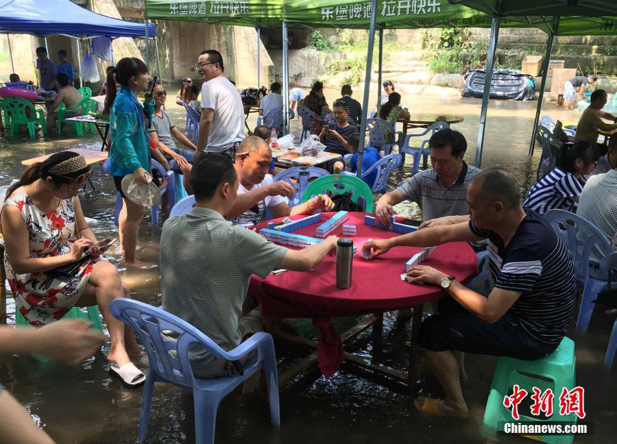 Playing Mahjong in the river: China's new way of tackling the summer heat