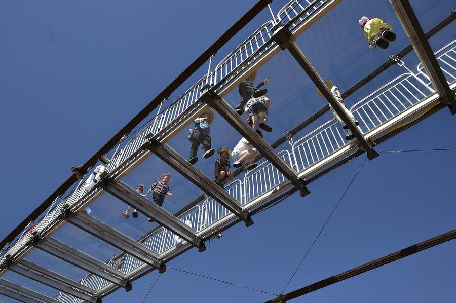 Tourists walk on glass bridge across Yellow River in Ningxia